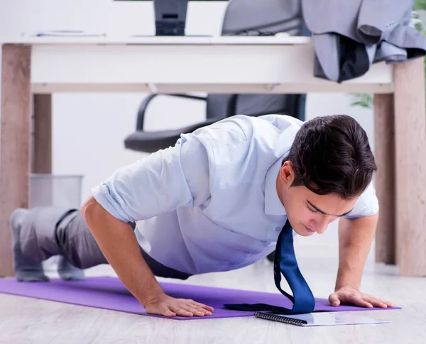 Empresario haciendo deportes en la oficina durante el descanso —  Fotos de Stock