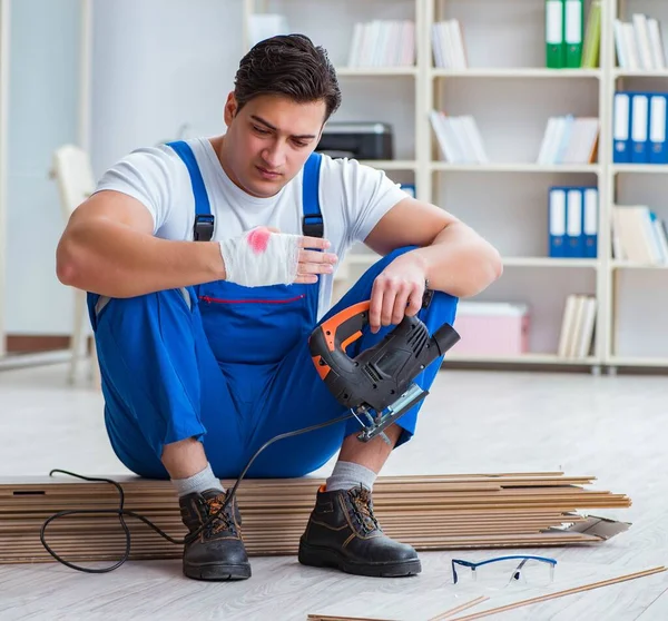 Trabajador joven que trabaja en baldosas laminadas piso — Foto de Stock