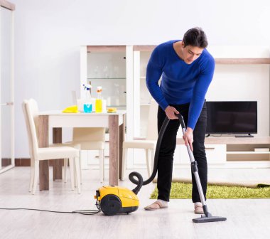 Genç adam evini temizliyor.