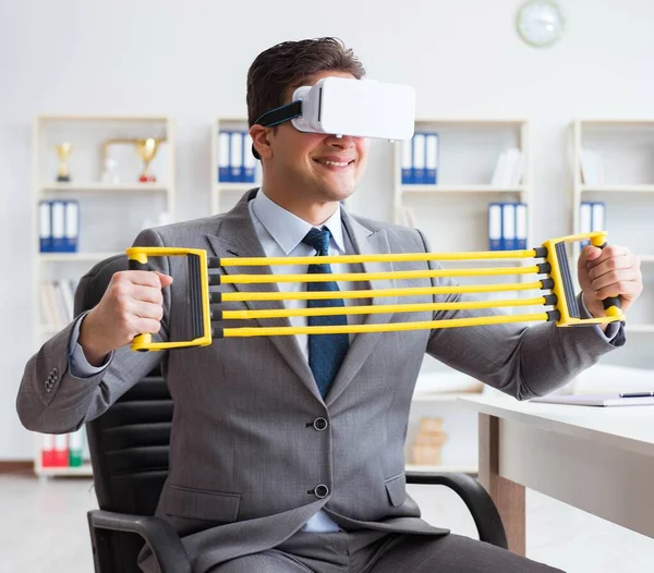 Homme d'affaires faisant de l'exercice avec un expanseur élastique portant des lunettes VR — Photo