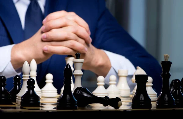 Businessman playing chess in strategy concept — Stock Photo, Image