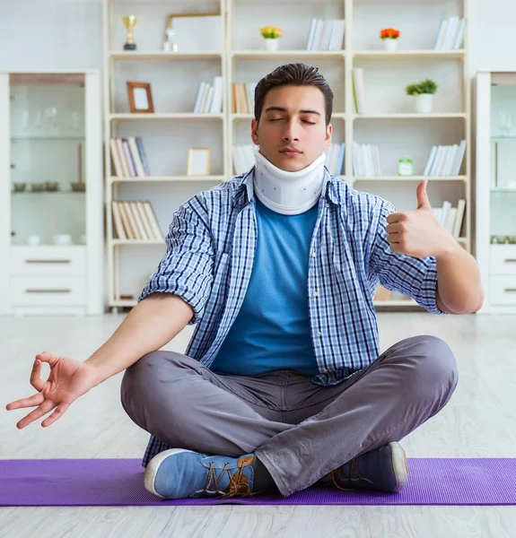 Uomo con lesioni al collo meditando a casa sul pavimento — Foto Stock