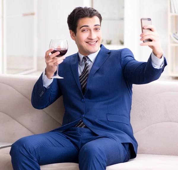 Uomo d'affari che beve vino seduto a casa — Foto Stock