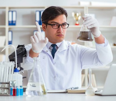 Genç araştırmacı bilim adamı bir su testi kirliliği araştırması yapıyor.