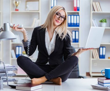 İş kadını ofiste meditasyon yaparken hayal kırıklığına uğradı