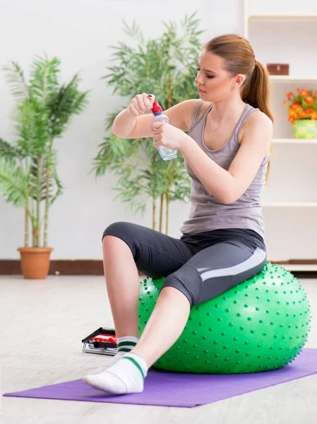 Mujer joven haciendo ejercicio con pelota de estabilidad en el gimnasio — Foto de Stock