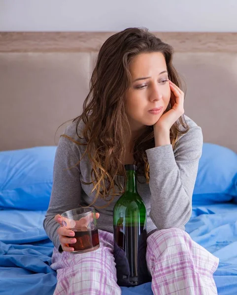 Mujer joven bebiendo alcohol deprimido en casa — Foto de Stock