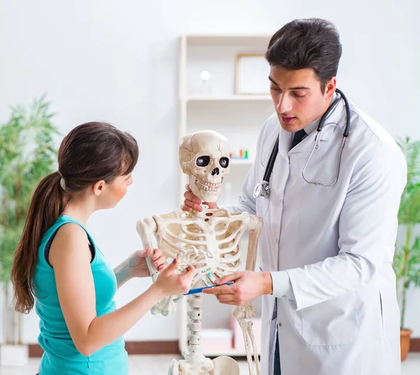 Médico mostrando tipo de lesión en el esqueleto al paciente — Foto de Stock