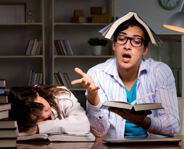 İki öğrenci geç saatlere kadar çalışıp sınavlara hazırlanıyor.