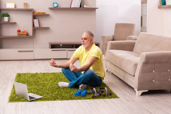 Hombre anciano haciendo ejercicios deportivos en casa — Foto de Stock