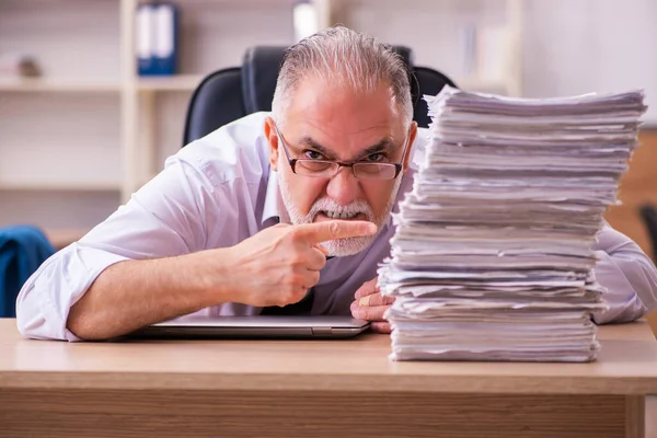 Ofisteki aşırı işten memnun olmayan yaşlı bir erkek işçi. — Stok fotoğraf