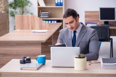 Ofiste çalışan genç bir erkek.