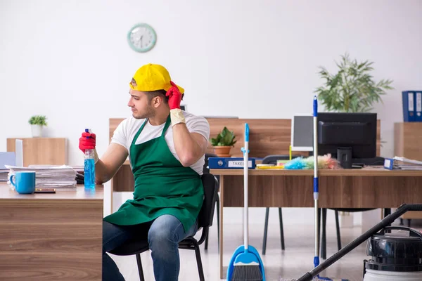 Joven contratista masculino limpiando la oficina — Foto de Stock