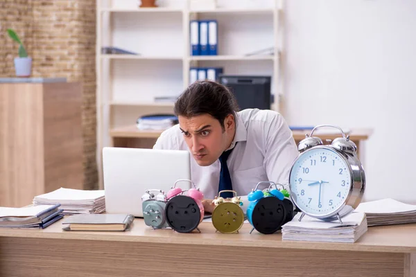 Young male employee afraid of missing deadline at workplace