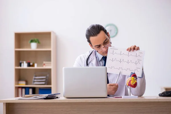 Joven médico cardiólogo buscando electrocardiograma — Foto de Stock