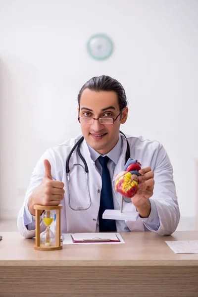 Junger männlicher Kardiologe im Zeitmanagement-Konzept — Stockfoto