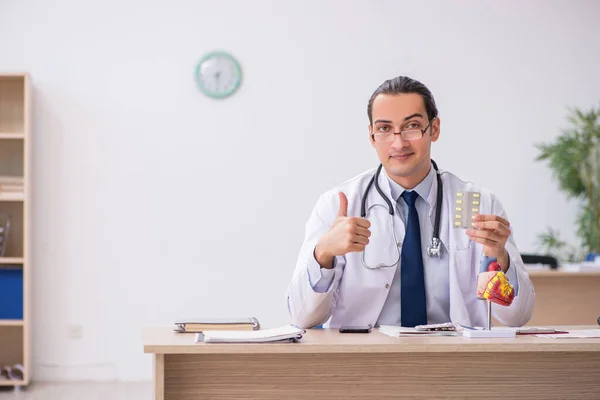 Junger männlicher Kardiologe schlägt Pillen vor — Stockfoto