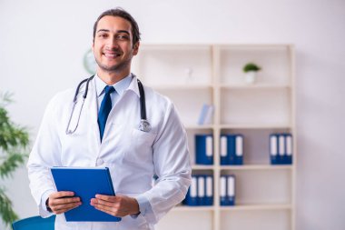 Klinikte çalışan yakışıklı genç bir doktor.