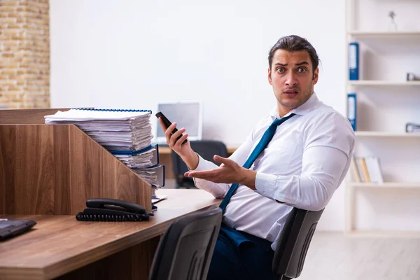 Young male employee unhappy with excessive work in the office — Stock Photo, Image