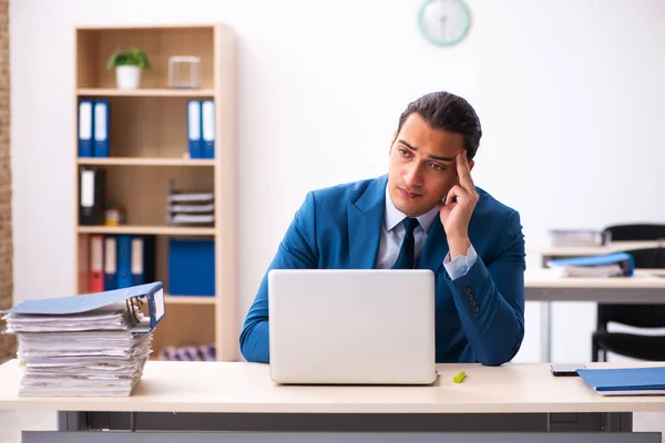 Jovem funcionário masculino infeliz com excesso de trabalho no escritório — Fotografia de Stock