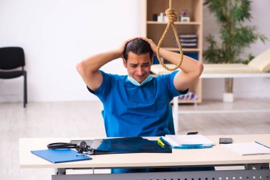 Genç erkek doktor iş yerinde intihar ediyor.