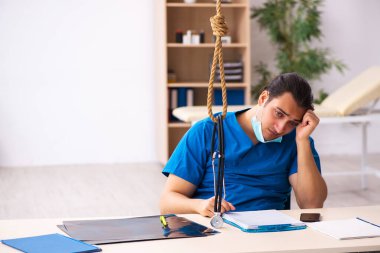 Genç erkek doktor iş yerinde intihar ediyor.