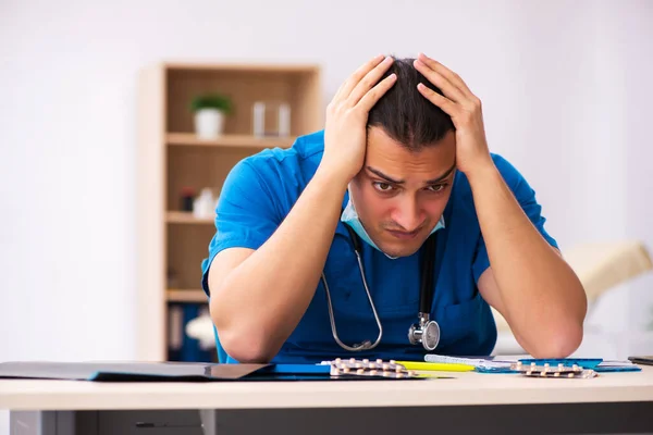 Young male doctor committing suicide at workplace — Stock Photo, Image