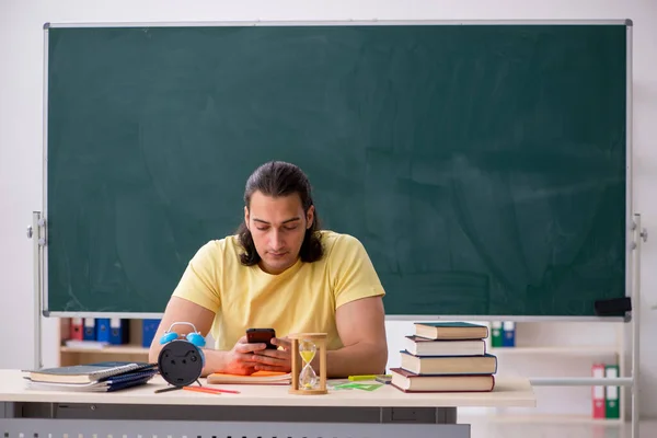 Joven estudiante masculino preparándose para los exámenes en el aula — Foto de Stock