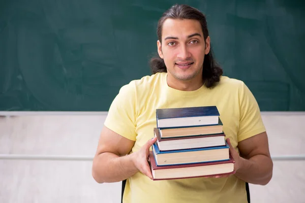 Jonge mannelijke student bereidt zich voor op examens in de klas — Stockfoto