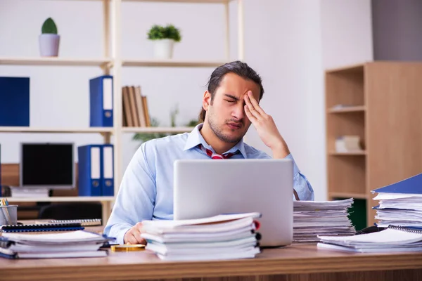 Jonge mannelijke werknemer ongelukkig met overmatig werk — Stockfoto