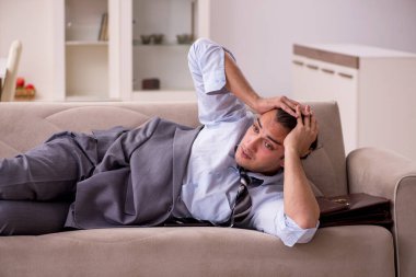 Yorgun genç işadamı işten sonra eve geliyor.