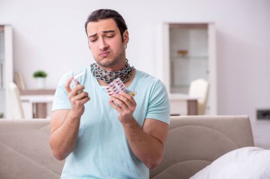 Genç adam boğaz ağrısı çekiyor.