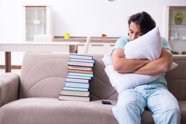 Genç erkek öğrenci evde sınavlara hazırlanmaktan yoruldu.