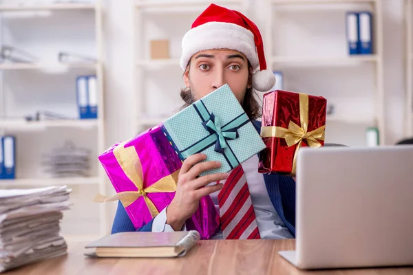 Ung manlig anställd på kontoret på julafton — Stockfoto