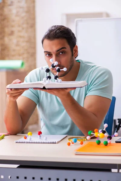 Jonge mannelijke student fysicus die thuis moleculair model studeert — Stockfoto