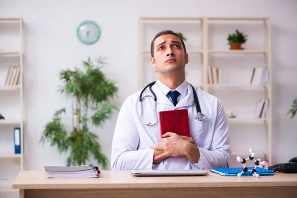 Jonge mannelijke student arts lezen boek in de kliniek — Stockfoto