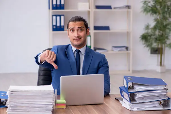 Jonge mannelijke werknemer ongelukkig met overmatig werk — Stockfoto