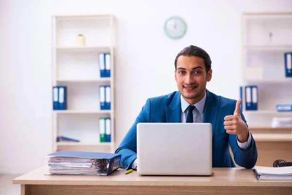 Young male employee and too many work in the office — Stock Photo, Image