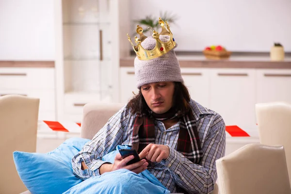 Mladý nemocný muž s chytrým telefonem doma během pandemie — Stock fotografie