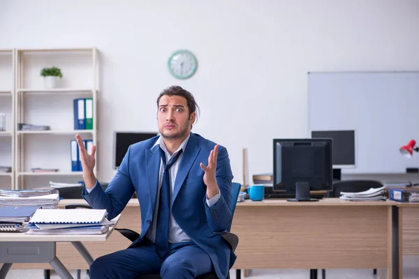 Jovem funcionário do sexo masculino infeliz com trabalho excessivo — Fotografia de Stock