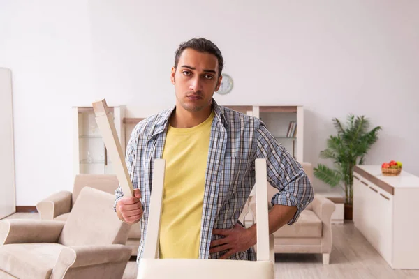 Joven carpintero masculino reparando muebles en casa — Foto de Stock