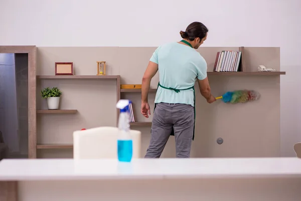 Jovem empreiteiro limpando a casa — Fotografia de Stock