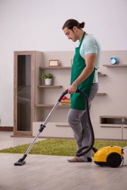 Genç erkek müteahhit evi temizliyor.