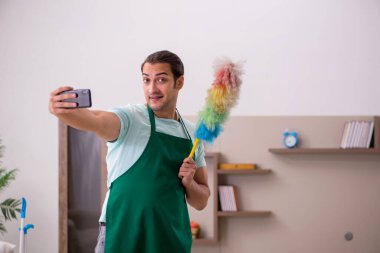 Genç erkek müteahhit evi temizliyor.