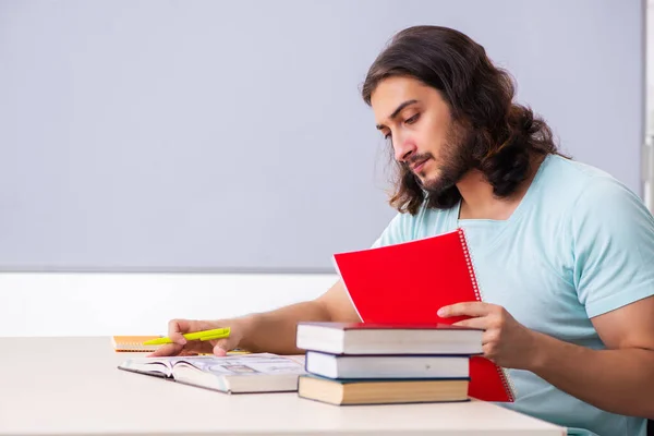 Jovem estudante se preparando para exames em sala de aula — Fotografia de Stock