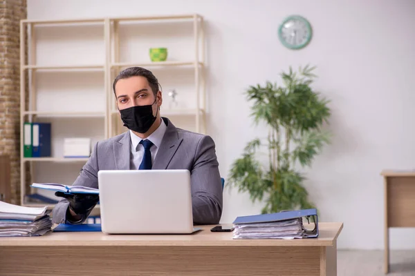 Joven empleado masculino en la oficina durante enfermedad pandémica —  Fotos de Stock