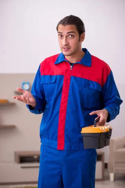 Young male contractor repairing furniture indoors — Stock Photo, Image