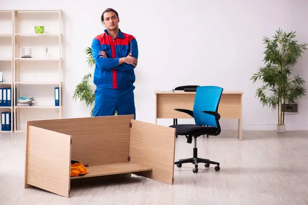 Joven contratista reparando muebles en la oficina — Foto de Stock