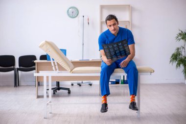 Genç erkek doktor radyoloji uzmanı gece vardiyasından sonra mutsuz oluyor.