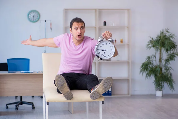 Paciente masculino joven que espera al médico en el concepto de gestión del tiempo — Foto de Stock